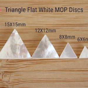May include: Four white triangle-shaped mother of pearl discs of varying sizes. The discs measure 15x15mm, 12x12mm, 8x8mm, and 6x6mm.