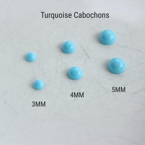 Op de afbeelding: Turquoise cabochons in verschillende maten, 3 mm, 4 mm en 5 mm, gerangschikt op een wit oppervlak. Turquoise cabochons.