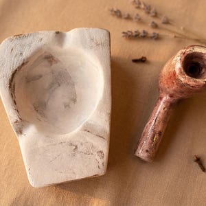 Könnte beinhalten: Eine weiße Keramik-Tasse mit schwarzem Henkel und dem Text "But First, Coffee" in handschriftlichem Stil. Die Tasse steht auf einer weißen Oberfläche. Die Tasse wird wahrscheinlich für Heißgetränke verwendet.