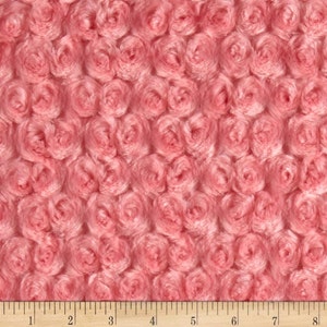 May include: Pink fabric with a rose pattern. The fabric is soft and fluffy, and the roses are raised and three-dimensional.