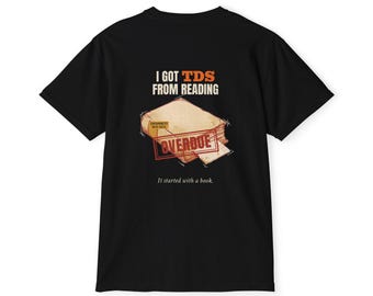Könnte beinhalten: Ein schwarzes T-Shirt mit einer Grafik eines Buches und einem roten Stempel mit der Aufschrift OVERDUE. Über dem Buch steht I GOT TDS FROM READING. Ein kleines Etikett auf dem Buch besagt CONTAMINATED WITH FACTS, darunter steht It started with a book.