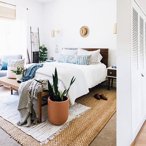 Peut inclure: Trois chambres &agrave; coucher avec literie blanche, meubles en bois et divers &eacute;l&eacute;ments de d&eacute;coration. La premi&egrave;re chambre dispose d'une t&ecirc;te de lit en bois avec un design tiss&eacute;, d'un tapis gris et d'une plante dans un pot en terre cuite. La deuxi&egrave;me chambre a un tapis blanc et une plante dans un pot en terre cuite. La troisi&egrave;me chambre a un tapis blanc, une table de chevet en bois et une guitare appuy&eacute;e contre le mur.