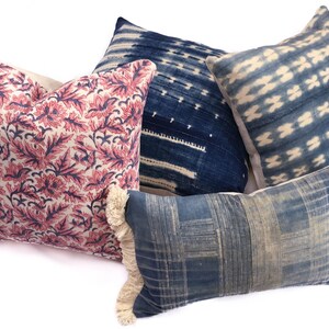 Peut inclure: Quatre coussins d&eacute;coratifs avec diff&eacute;rents motifs et couleurs. Deux coussins pr&eacute;sentent un motif ikat bleu et blanc, un coussin a un motif floral rose et bleu et un coussin a un motif g&eacute;om&eacute;trique bleu et blanc.
