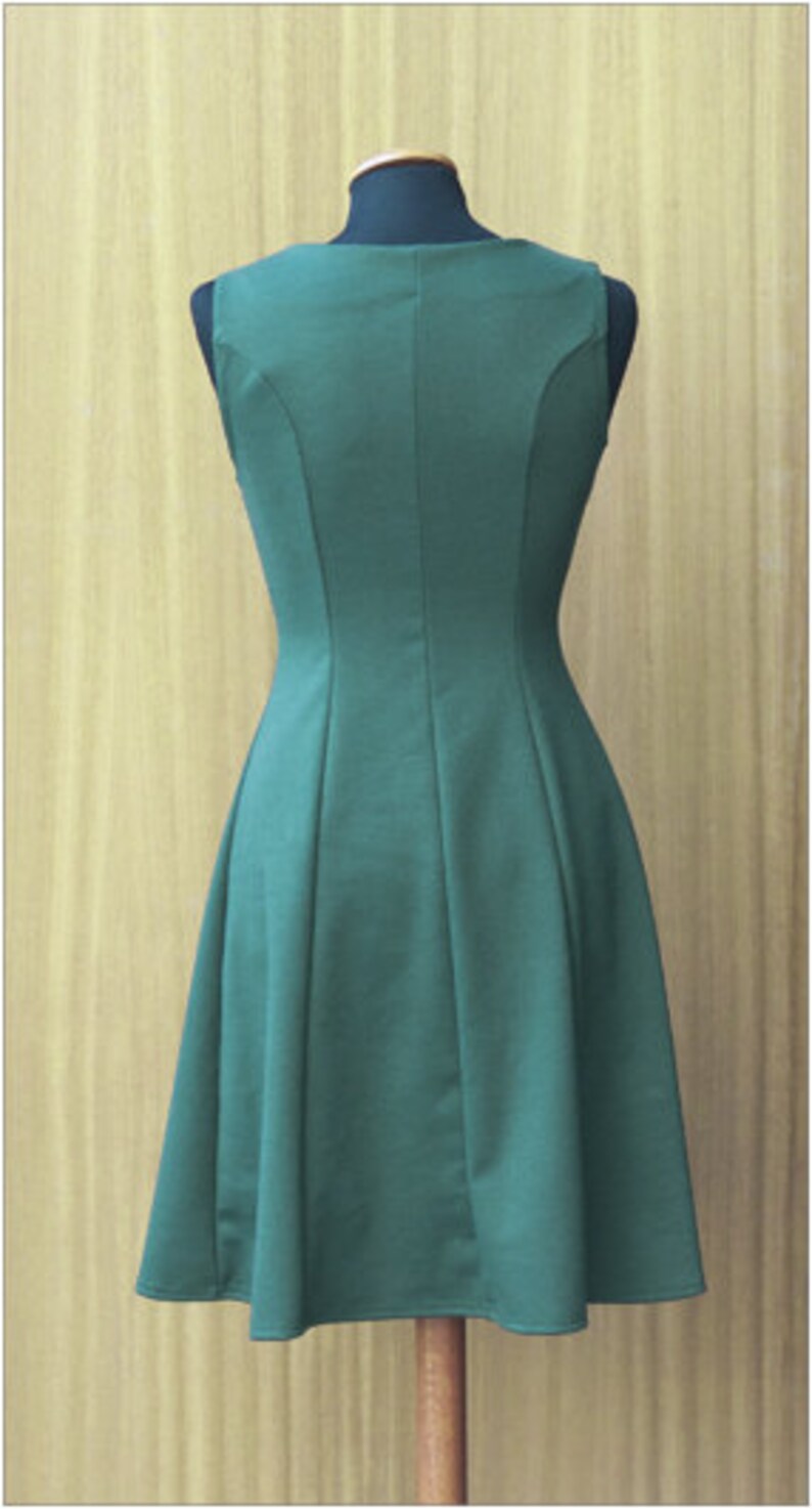 May include: A sleeveless, dark green dress with a fitted bodice and a flared skirt. The dress has a simple, elegant design.
