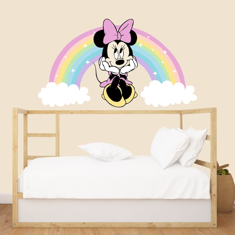 Pode incluir: Um adesivo de parede de arco-&iacute;ris colorido com uma imagem de desenho animado de Minnie Mouse sentada em uma nuvem. O adesivo &eacute; perfeito para o quarto de uma crian&ccedil;a ou uma sala de jogos.