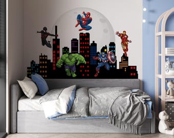 May include: A child's bedroom featuring a wall decal of Marvel superheroes, including Spider-Man, Hulk, Captain America, and Iron Man, above a gray bed with blue and white bedding. A cityscape silhouette is below the characters.