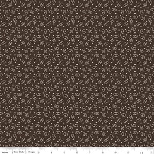 May include: A brown fabric with a repeating pattern of white interlocking circles and small white dots.