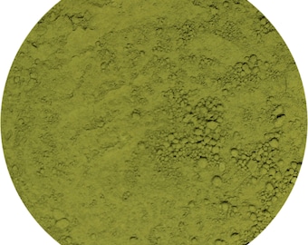 May include: A close-up view of a pile of green matcha powder. The powder is finely ground and has a smooth, consistent texture.