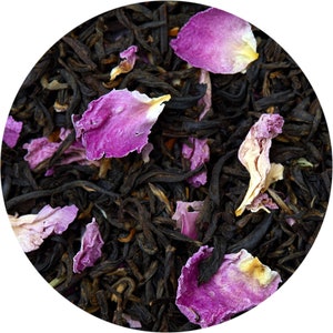 May include: Close-up of black tea leaves with pink and white rose petals. The tea blend is a mix of black tea and rose petals.