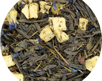 May include: A close-up of a green tea blend with dried fruit and flower pieces. The tea includes dried apple pieces, cornflower petals, and green tea leaves.
