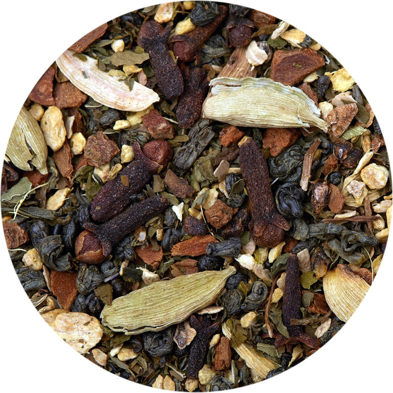 Puede incluir: Primer plano de una mezcla de t&eacute; verde, especias y frutas secas. La mezcla incluye hojas de t&eacute; verde, clavos, vainas de cardamomo, palitos de canela y c&aacute;scara de naranja seca.