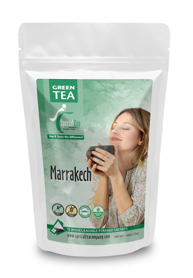 Puede incluir: Una bolsa blanca con una etiqueta verde que muestra a una mujer disfrutando de una taza de t&eacute;. La etiqueta dice "GREEN TEA", "Special Tea Company", "Designer Teas", "You'll Taste the Difference!" y "Marrakech". La etiqueta tambi&eacute;n incluye 15 bolsitas piramidales biodegradables, una direcci&oacute;n de sitio web y un peso neto de 30 g.