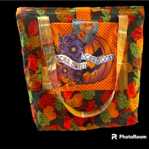 May include: A black tote bag with orange, green and red autumn leaves and a pumpkin with the text "Sorta Sweet Sorta Spooky" on the front.