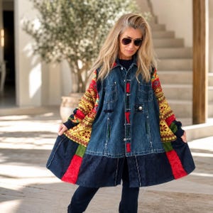 Könnte beinhalten: Eine langärmelige Jacke mit einem dunkelblauen Jeans-Oberteil und durchgehender Knopfleiste, kombiniert mit kontrastierenden Ärmeln und einem unteren Saum aus buntem, gelb-rot-grünem Strickstoff mit geometrischen und floralen Mustern.