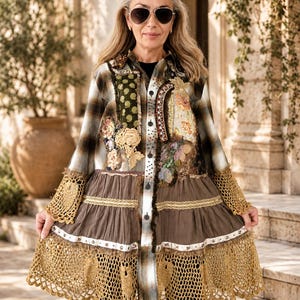May include: A long-sleeved button-down shirt featuring a brown and white plaid pattern, embellished with various fabric patches, floral lace appliqués, and beaded details. The lower section has a brown tiered skirt with gold crochet trim.