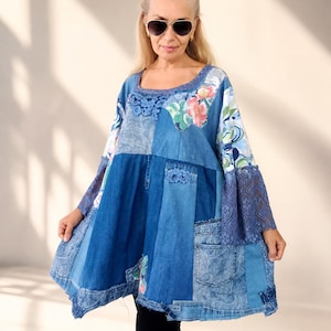 Könnte beinhalten: Eine Patchwork-Tunika aus verschiedenen Blautönen von Denim, mit floralen Stoffeinsätzen, detaillierten Spitzenverzierungen, einem weiten Rundhalsausschnitt und ausgestellten Ärmeln. Das Kleidungsstück zeigt eine Mischung aus Texturen und Taschen.