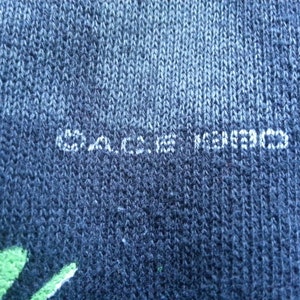 May include: Close-up of a dark blue fabric with the text "C.A.C.I.E.S. KOREA" printed in white.