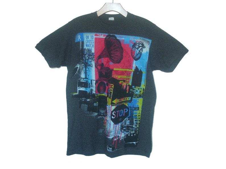 May include: A dark gray t-shirt with a colorful graphic print featuring a vintage gramophone, a heart, a stop sign, and the text "OK to cross watch".
