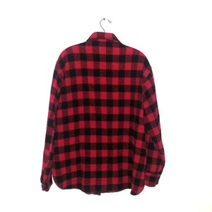 May include: A red and black plaid flannel shirt with long sleeves and a button-up front.