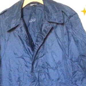 May include: A dark blue raincoat with a button closure and a collar. The raincoat has a smooth, shiny finish.