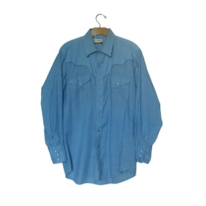 May include: A blue and white striped long-sleeve shirt with a pointed collar and pearl snap buttons. The shirt has two chest pockets with pearl snap closures.