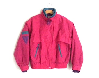May include: A pink vintage jacket with teal and purple accents. The jacket has a zipper closure and two pockets on the front.