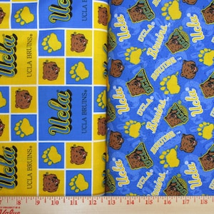 May include: Two fabric swatches with a repeating pattern of the UCLA Bruins logo, a bear head, and paw prints. The fabric on the left is yellow with blue accents, and the fabric on the right is blue with yellow accents. The text "UCLA Bruins" is repeated on both fabrics.