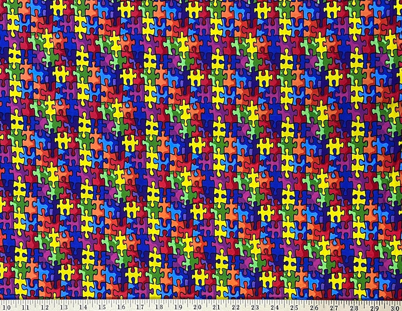 May include: A colorful fabric with a repeating pattern of puzzle pieces in shades of blue, red, yellow, green, and purple. The puzzle pieces are arranged in a diagonal pattern.