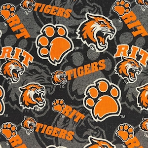 May include: Fabric with a repeating pattern of orange tiger heads, paw prints, and the text "RIT TIGERS" in orange on a dark gray background. The tiger heads are roaring, and the paw prints are outlined in black.