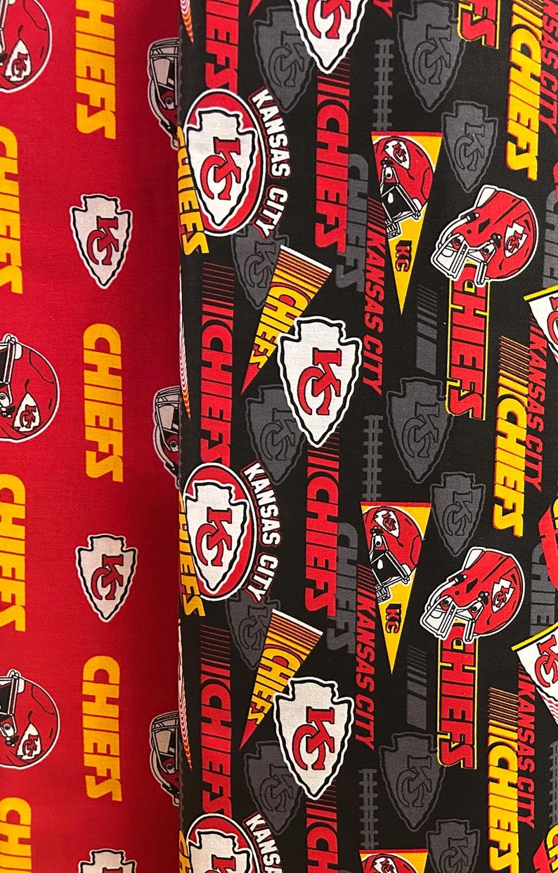 K&ouml;nnte beinhalten: Zwei Stoffrollen mit einem sich wiederholenden Muster des Kansas City Chiefs-Logos, Helmen und Text. Eine Rolle ist rot, die andere ist schwarz. Die Logos sind wei&szlig;, rot und gelb.
