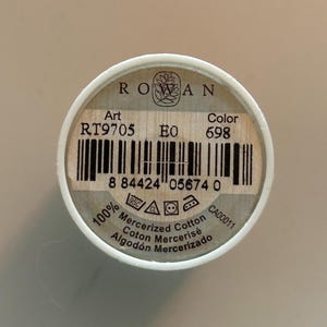 May include: A spool of Rowan mercerized cotton thread. The label displays the brand name, product details, and a barcode. The color is 698. The thread is 100% mercerized cotton.
