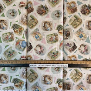 May include: White fabric with a repeating pattern of green, pink, and blue triangles and illustrations of Peter Rabbit characters. The fabric is labeled "CAROLINA COTTON COMPANY - KINGS MOUNTAIN, NC".