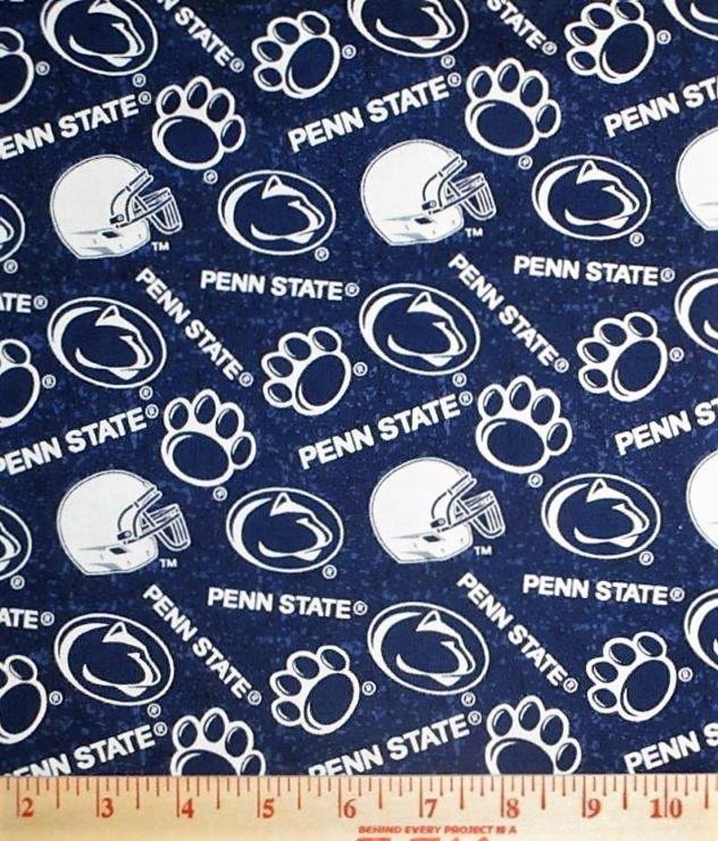 May include: Navy blue fabric with a repeating pattern of white Penn State logos, football helmets, and paw prints. The words "PENN STATE" are also printed on the fabric. The fabric is measured in inches.