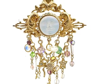 Spilla vintage Kirks Folly color oro con luna e vista sul mare, strass e ciondoli mistici.