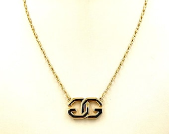 May include: A gold chain necklace with a black enamel double GG pendant.