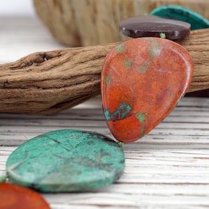 Puede incluir: Una hebra de cuentas de piedras preciosas con una mezcla de turquesa y marrón rojizo. Las cuentas tienen forma de lágrima y tienen un aspecto natural y orgánico.