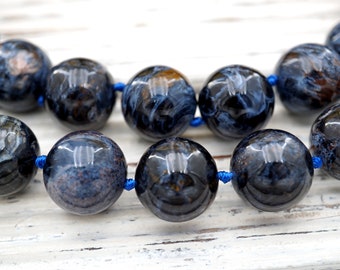 May include: A necklace made of dark blue and brown tiger's eye beads with a blue cord.