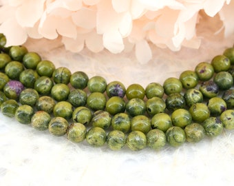Puede incluir: Una hebra de cuentas redondas moteadas de verde y marrón. Las cuentas están hechas de piedra natural y tienen un acabado liso y pulido.