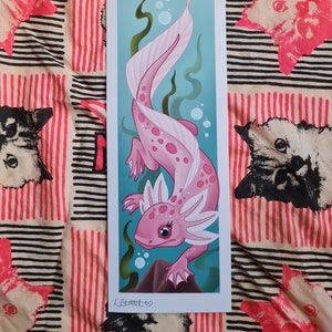 May include: A pink axolotl with white feathery gills swims in a blue and green underwater scene. The axolotl has pink spots and is surrounded by bubbles. The image is signed "LStreet" in the bottom left corner.