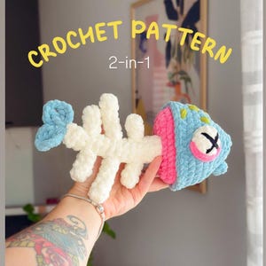 May include: A plush crochet fish skeleton toy featuring a white spine, a light blue tail, and a light blue head with a pink accent, a closed eye with black stitching, and yellow spots. The text CROCHET PATTERN 2-in-1 is displayed above the toy.