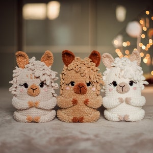 May include: Three handmade crochet llama dolls in cream, tan, and brown. Each llama has a fluffy head, small ears, and a sweet face with closed eyes. The dolls are sitting side-by-side.