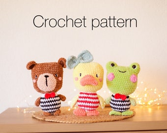 May include: Crochet pattern for a brown bear, yellow duck, and green frog. Each plush toy is wearing a black and white striped outfit with a red bow tie.