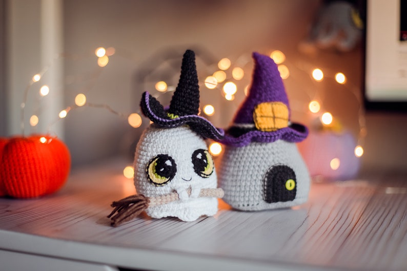 May include: Two crocheted Halloween decorations, a ghost wearing a witch's hat and a witch's house with a door and a window.
