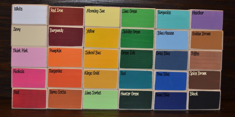 May include: A collection of small, rectangular wooden blocks, each painted a different color. The blocks are labeled with color names like "White," "Red Iron," "Morning Sun," and "Lime Green." The color palette includes a variety of hues, from vibrant to muted.