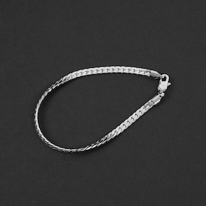 Puede incluir: Un brazalete de cadena de plata con cierre de langosta.