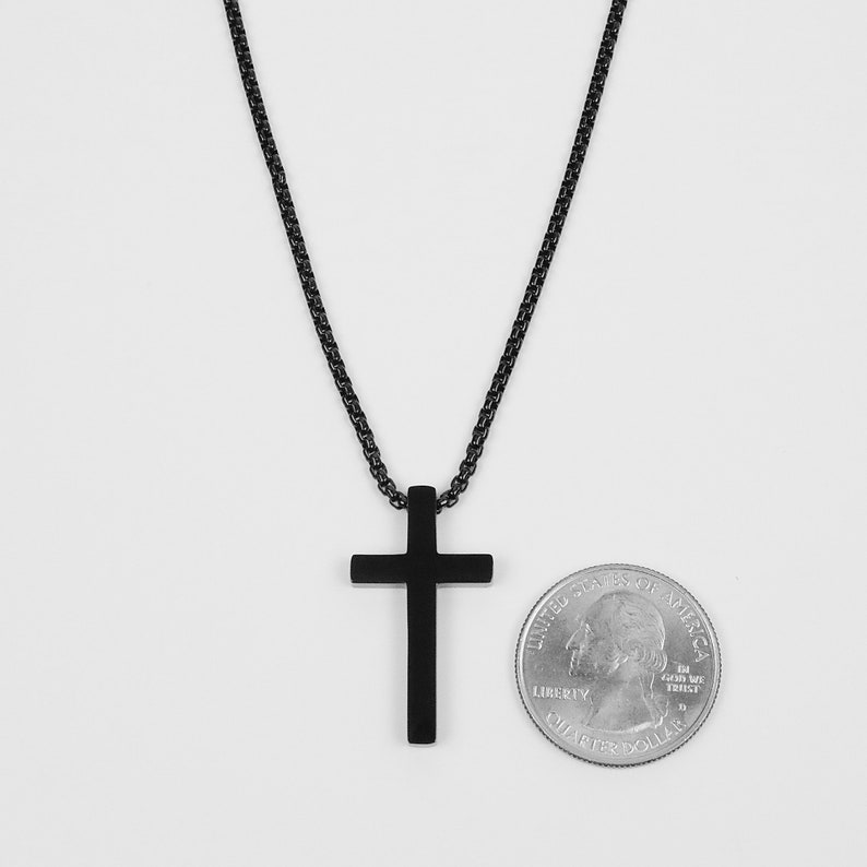 May include: A black chain necklace with a black cross pendant. The pendant is about the size of a US quarter.