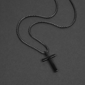 May include: A black chain necklace with a black cross pendant.