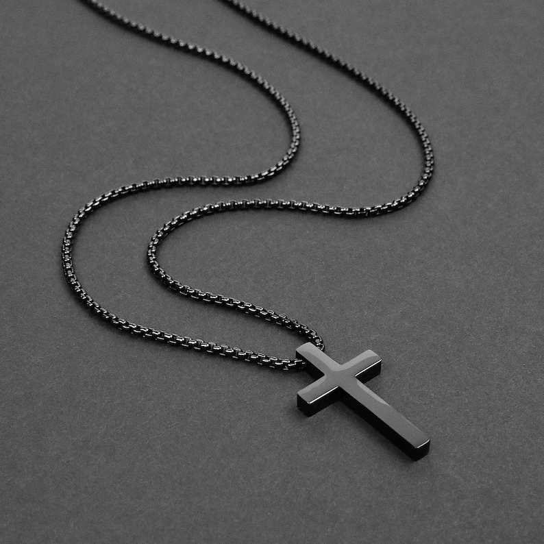 May include: A black chain necklace with a black cross pendant.
