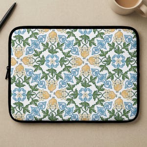 May include: A white ceramic mug with a black handle and the text "But First, Coffee" in a bold, black font. The mug is set against a blurred background, suggesting a cozy setting.