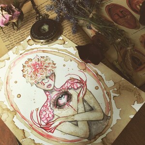 May include: Watercolour painting of a woman with a flower crown on her head and a large eye on her chest. The painting is done in shades of pink, red, and white, and is set against a background of brown paper with coffee stains.